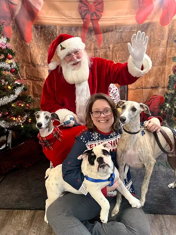 Pet owner posing with three dogs and Santa at the Santa Paws charity event in Carol Stream