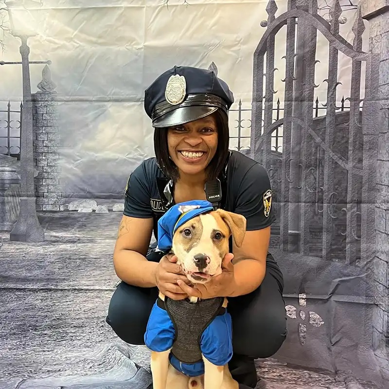 Owner and dog in matching police Halloween costumes at a Howl-o-Ween pet event in Carol Stream
