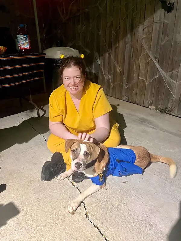 Staff member and dog wearing matching Halloween costumes at a Howl-o-Ween event in Carol Stream