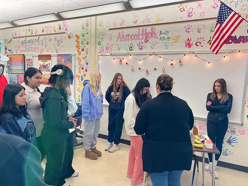 Students gathered around a veterinary professional during an educational classroom activity in Carol Stream