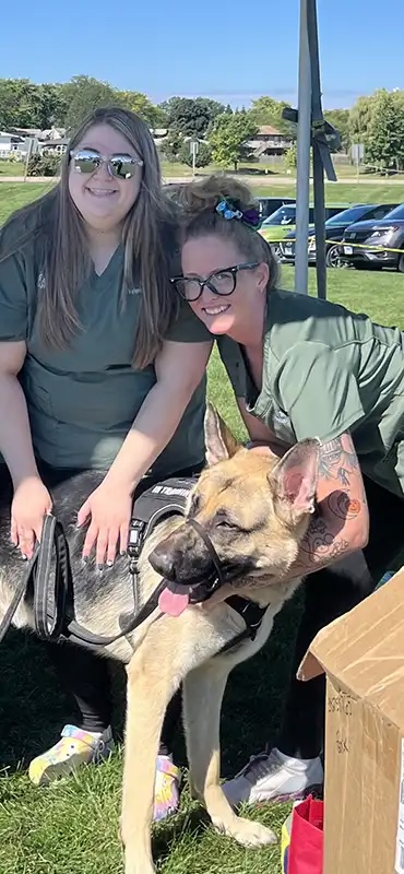 Veterinary team smiling with a German Shepherd at the first aid tent during the charity dog show in Carol Stream