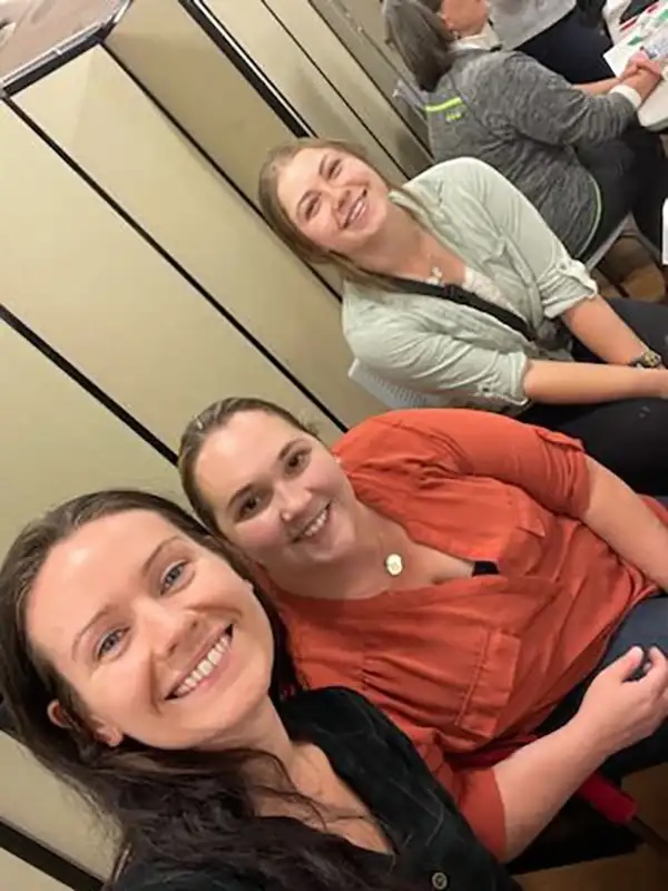 Three veterinary team members smiling at a community education event in Carol Stream