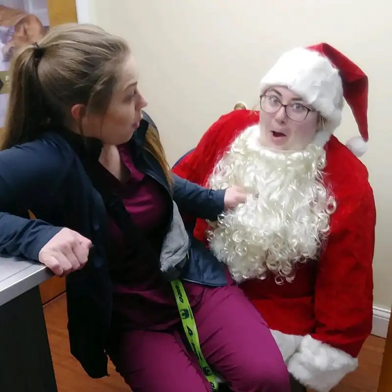 Veterinary staff member and Santa sharing a fun moment at the Santa Paws event in Carol Stream